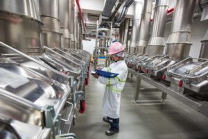 Male worker inspecting food or beverage production in a facility