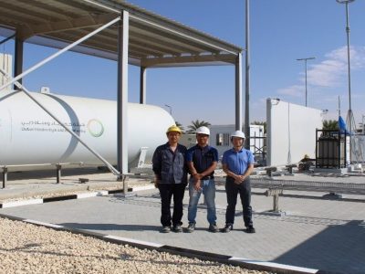 Three people at DEWA-ENOC green hydrogen station
