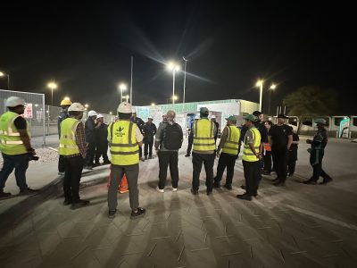 Workers at a nighttime Crystal safety briefing on-site